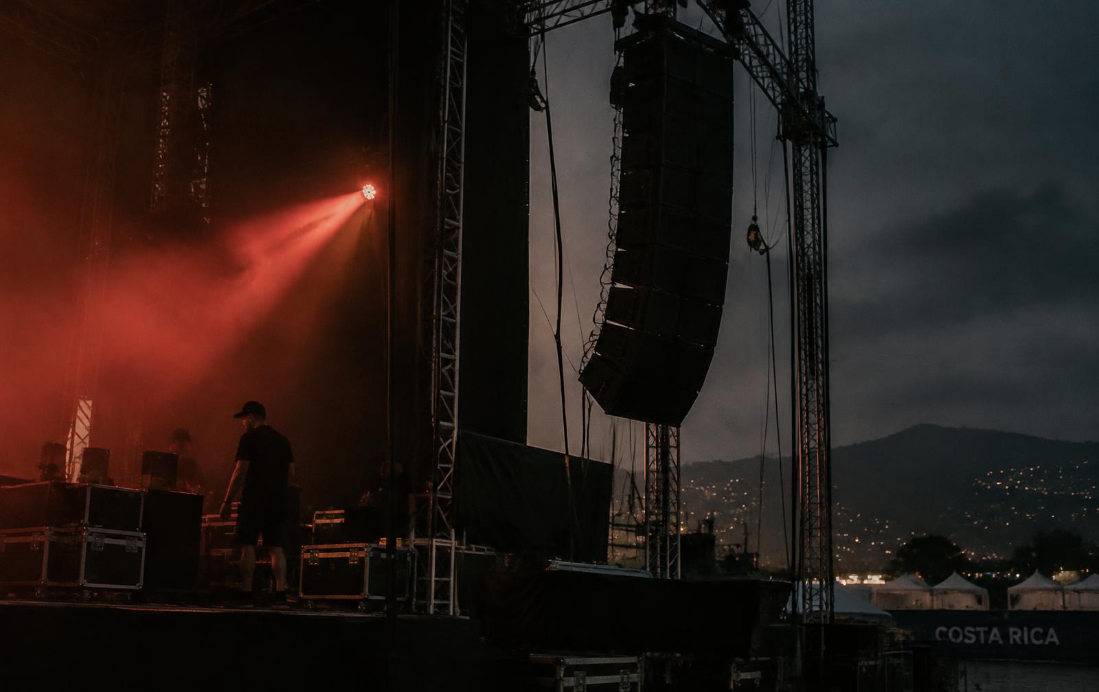 Escenario en montaje con line array y luz roja